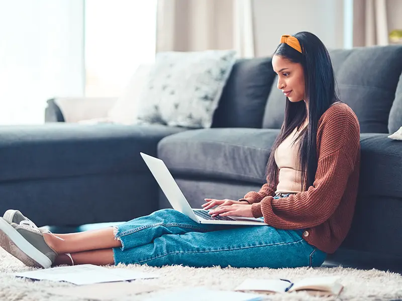 student sitting on floor on laptop