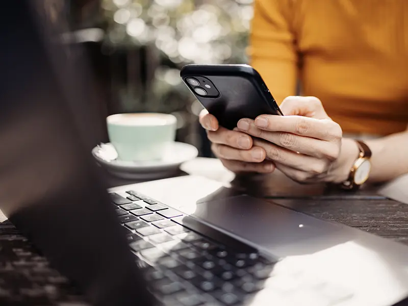 woman on phone and laptop